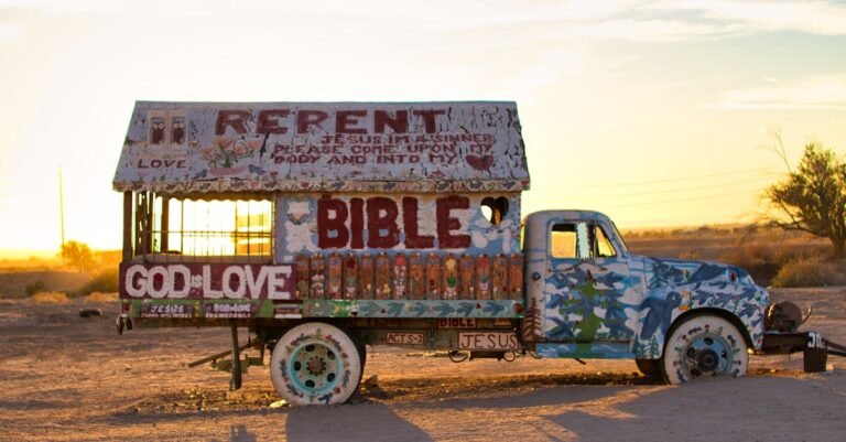 Colorful artistic truck with biblical messages captured at sunset in a desert landscape.
