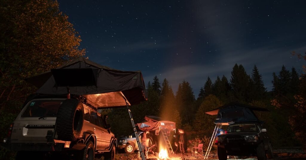 Camping scene with cars and tents under a starry night sky, featuring a cozy bonfire in the forest.